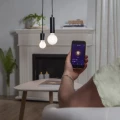 Sterowanie żarówką LED smart E27 za pomocą aplikacji w smartfonie, dwie lampy wiszące nad stolikiem w salonie.