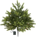 Sztuczna choinka z gęstymi gałązkami i wbudowanymi diodami LED, zakończona szpicem zasilanym bateryjnie, przeznaczona do wbicia w podłoże.