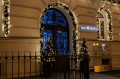 Girlandy ze sztucznego igliwia świerkowego ozdobione ciepłymi światełkami LED zdobiące wejście do hotelu, tworzące elegancką, świąteczną iluminację budynku.