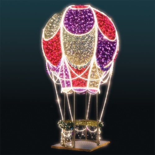 luminacja LED w formie balonu 3D z dekoracyjnym poszyciem w odcieniach fioletu, czerwieni i złota, ozdobiona bombkami i świetlnymi girlandami, umieszczona na metalowej podstawie z koszem dekoracyjnym i świątecznym oświetleniem.