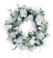 Zimowy wieniec z białymi bombkami, kwiatami i drobnymi akcentami zieleni – subtelna, elegancka dekoracja o śnieżnym charakterze.