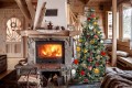 Choinka ZOYA udekorowana bombkami i światełkami, ustawiona przy kominku w drewnianym wnętrzu w stylu góralskim.