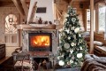 Choinka HANA ozdobiona białymi dekoracjami i światełkami LED, ustawiona przy kominku w drewnianym wnętrzu w stylu góralskim.