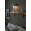 Biała lampa stołowa LED MUSHROOM zamontowana jako lampka przy łóżku, subtelne oświetlenie nowoczesnej sypialni.