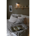 Biała lampa LED MUSHROOM zamontowana przy łóżku jako kompaktowe oświetlenie do czytania i oświetlenie pomocnicze.