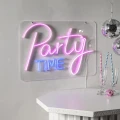 Neon LED Party Time w różowo-niebieskim świetle, zawieszony na szarej ścianie obok wiszących kul disco. Na białym blacie stoją kieliszki z kolorowymi słomkami i mała różowa kula.