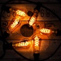 Girlanda ogrodowa z żarówkami ST64 3,2W 2100K Decoled Amber w bursztynowym szkle. Ciepłe światło spiralnych żarników LED oświetla drewniany kabel bębnowy, tworząc efektowną kompozycję świetlną.