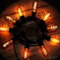 Girlanda ogrodowa z żarówkami LED T45 2,8W 2200K z serii Decoled Amber, ułożona na drewnianej szpuli. Podłużne bursztynowe żarówki świecą ciepłym światłem, osadzone w czarnych oprawkach na elastycznym kablu.