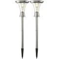 Dwie solarne lampy ogrodowe w kolorze stali nierdzewnej z przezroczystymi kloszami, osadzone na szpilkach, przedstawione na białym tle.