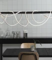 Wąż LED biały zamontowany w aranżacji wnętrza, tworzący dekoracyjne fale nad stołem w nowoczesnej jadalni.