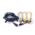 Zielona girlanda świetlna z oprawkami E27, zwinięta w pętlę, z trzema wkręconymi żarówkami LED A60 6,5W 2100K z 3-stopniowym ściemnianiem. Żarówki emitują ciepłe światło o różnej intensywności. Zdjęcie na białym tle.