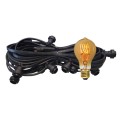 Czarny przewód girlandy ogrodowej z oprawkami E27 i żarówką LED TA60 2,5W 2000K z bursztynowego szkła z serii Decoled Amber, emitującą ciepłe światło o dekoracyjnym, spiralnym żarniku.