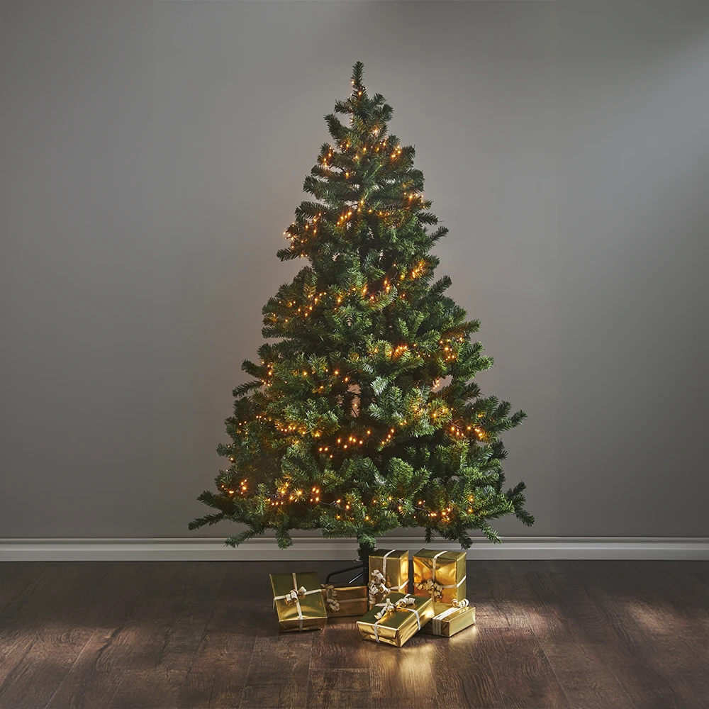 Lampki choinkowe LED 100 diod 7 m FLASHY, owinięte na sztucznej choince w salonie, ciepłe światło 1900K tworzy przytulną atmosferę świąteczną.