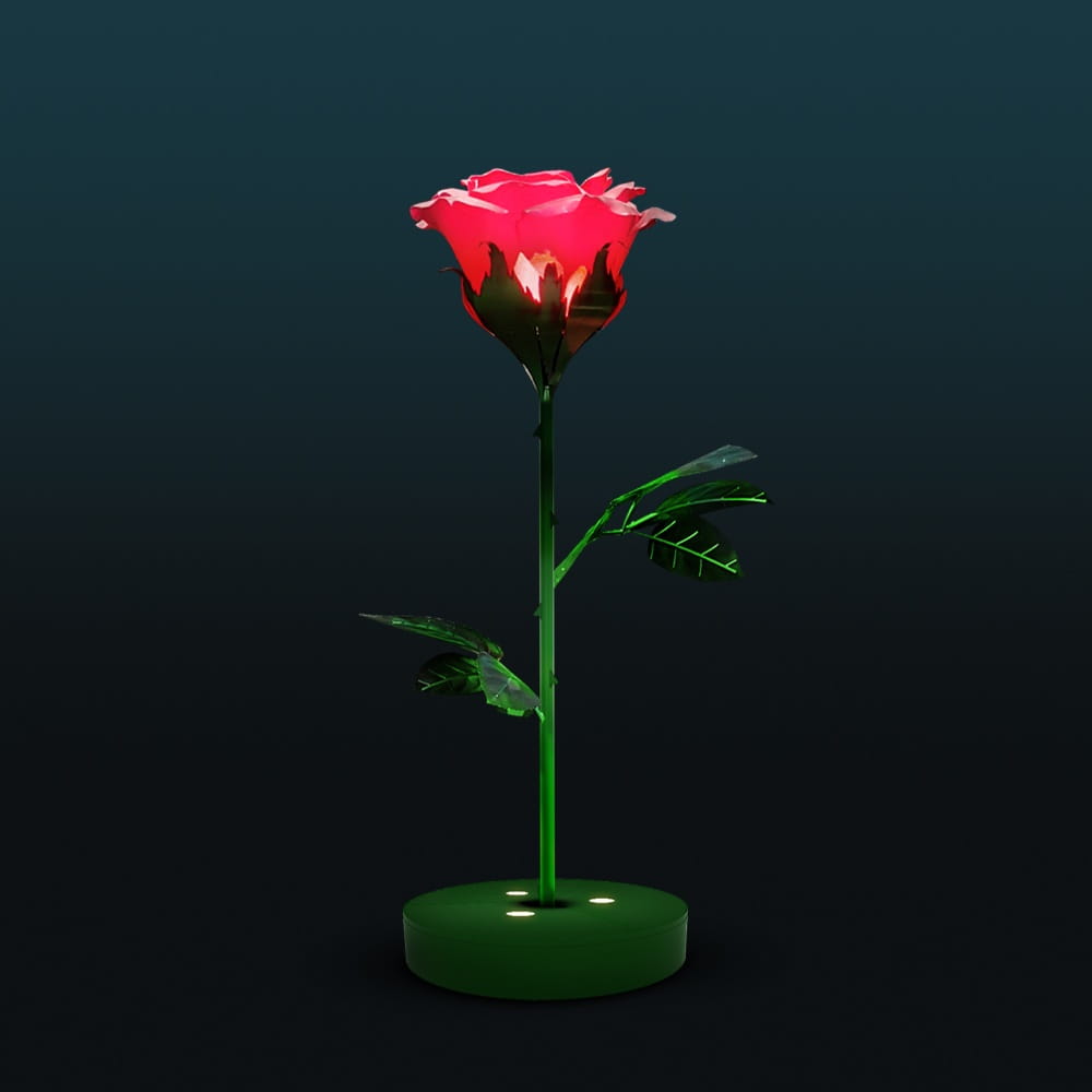 Dekoracja świetlna LED w kształcie róży na ciemnym tle, nowoczesny fotopunkt z podświetlanym kwiatem i zieloną łodygą, przeznaczony do przestrzeni miejskich, parków i instalacji plenerowych.