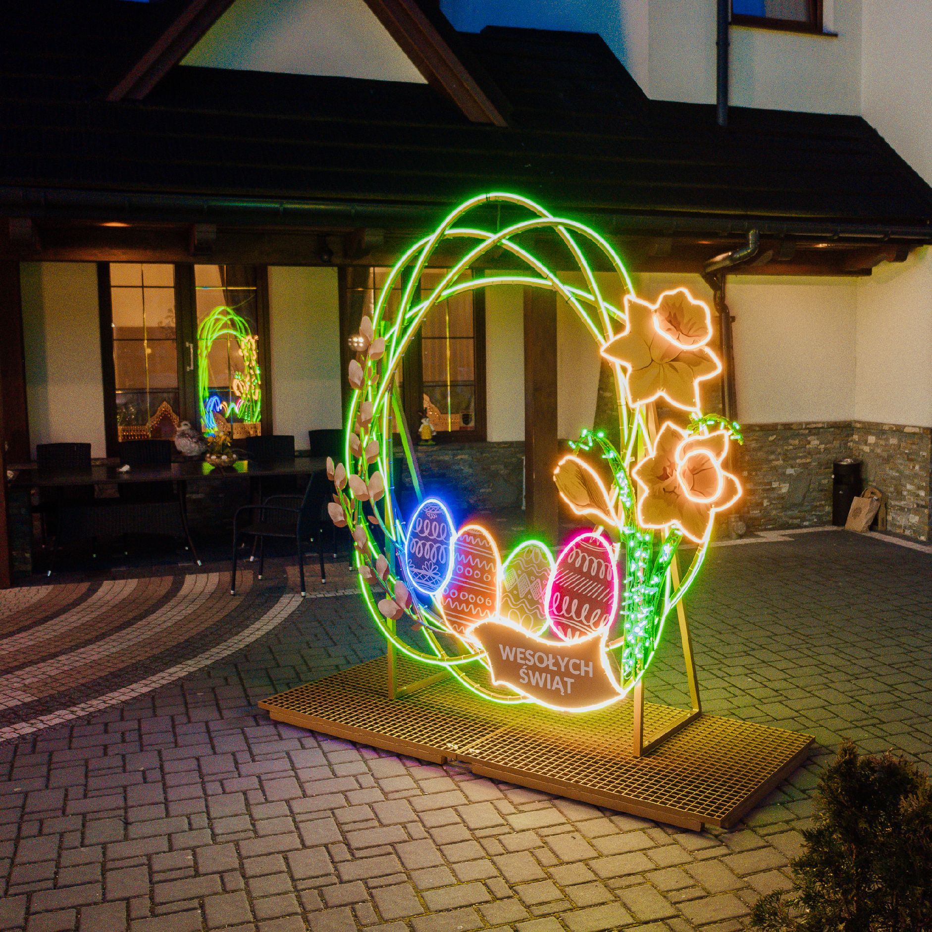 Iluminacja wielkanocna Bramka Wiosna 3D LED z zieloną konstrukcją, kolorowymi pisankami i kwiatami, dekoracja plenerowa do miast i obiektów komercyjnych, widok boczny.