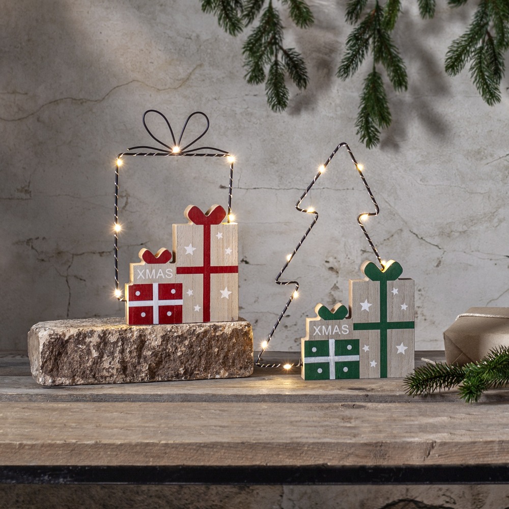 Dwie świąteczne dekoracje LED z drewna: zestaw prezentów oraz choinka z drewnianymi pakunkami, podświetlone ciepłym światłem, ustawione na drewnianym blacie, z delikatnymi gałązkami świerku w tle.