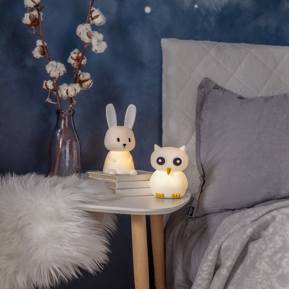 Lampki nocne zwierzątka z ciepłym, miękkim światłem, ustawione obok łóżka, zapewniają subtelne oświetlenie i przyjazną atmosferę przed snem.