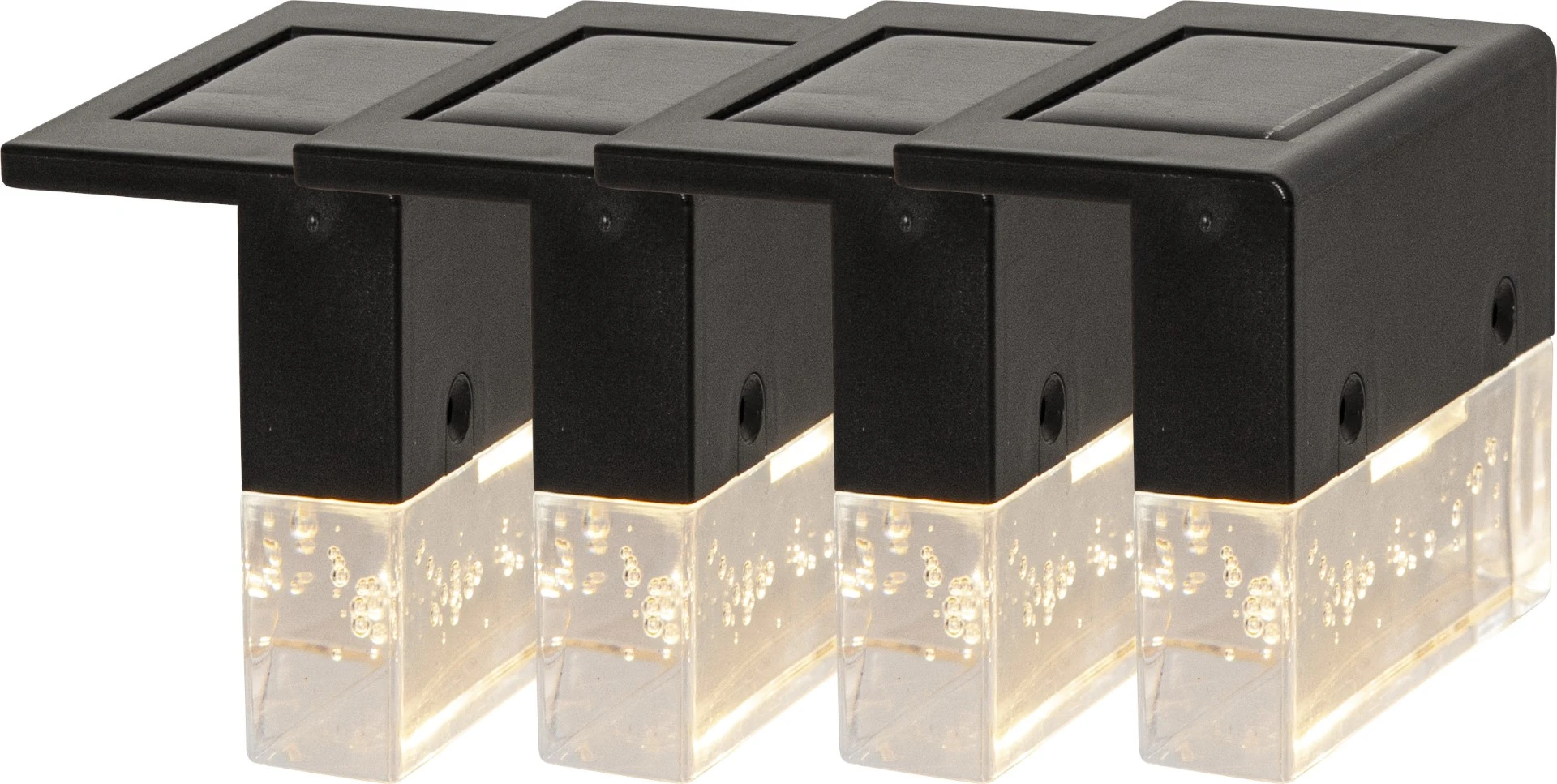 Zestaw czterech solarnych lamp LED z czarną obudową i transparentnym kloszem z efektem bąbelków emituje ciepłe światło, tworząc dekoracyjne i funkcjonalne oświetlenie ogrodzenia, balustrady lub tarasu.