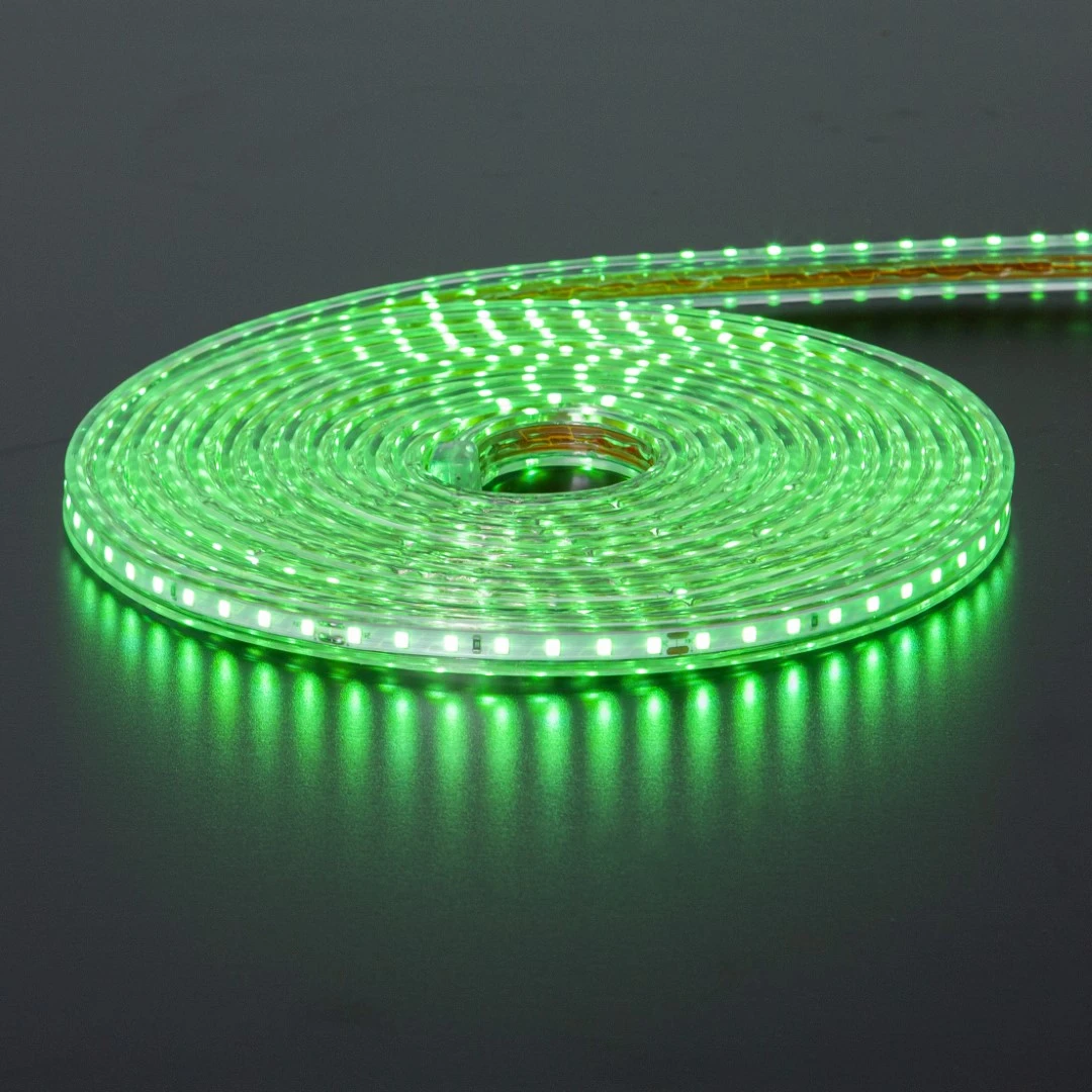 Zielona taśma LED zwinięta w spiralę, emitująca intensywne światło na ciemnym podłożu, z wyraźnym odbiciem poświaty.