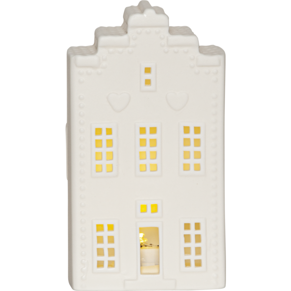 Biała ceramiczna dekoracja w formie domku z podświetlanymi oknami; frontowy widok na jasnym tle, widoczne detale fasady i ciepłe światło wewnątrz.